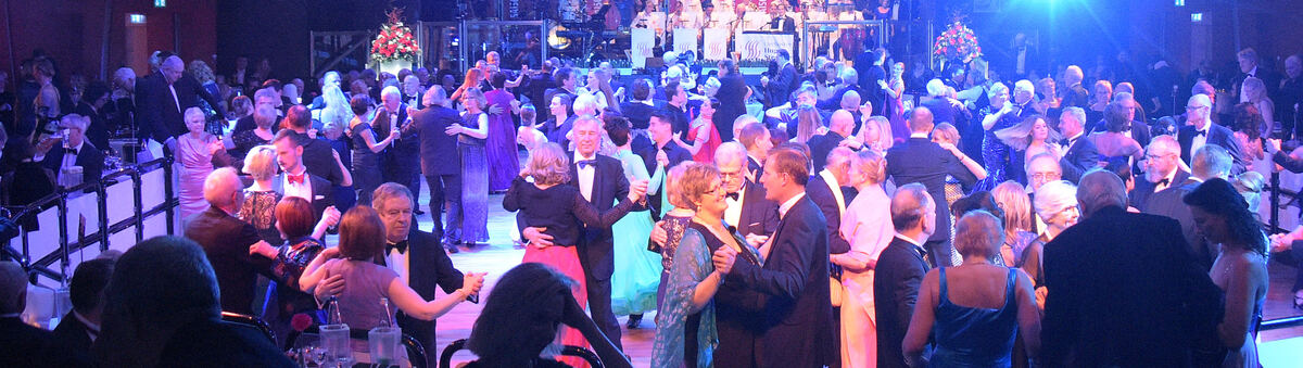 Vollbesetzter Ballsaal mit festlicher Beleuchtung